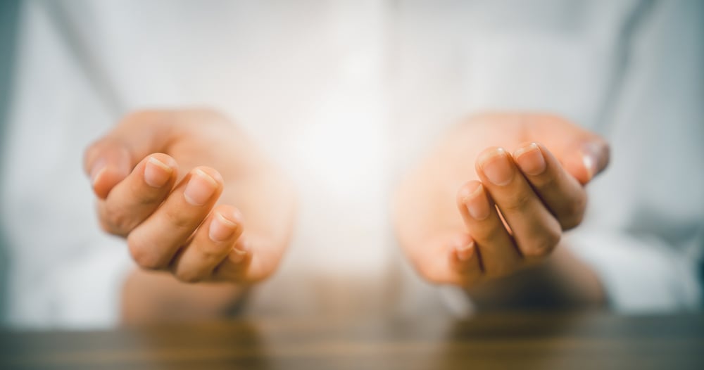 Woman hands praying (makes a dua) and light on palm.